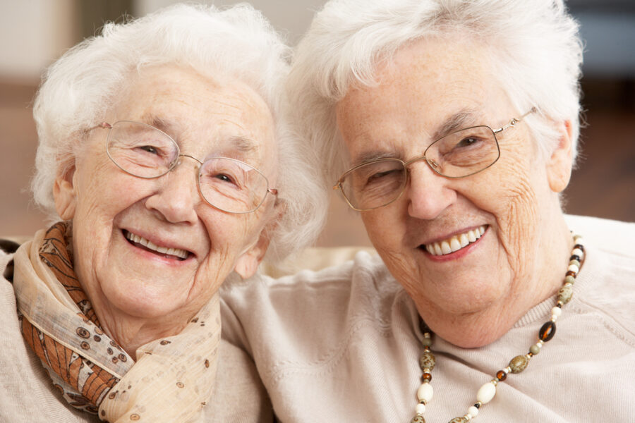 Featured image showing two senior woman smiling with their arms around each other